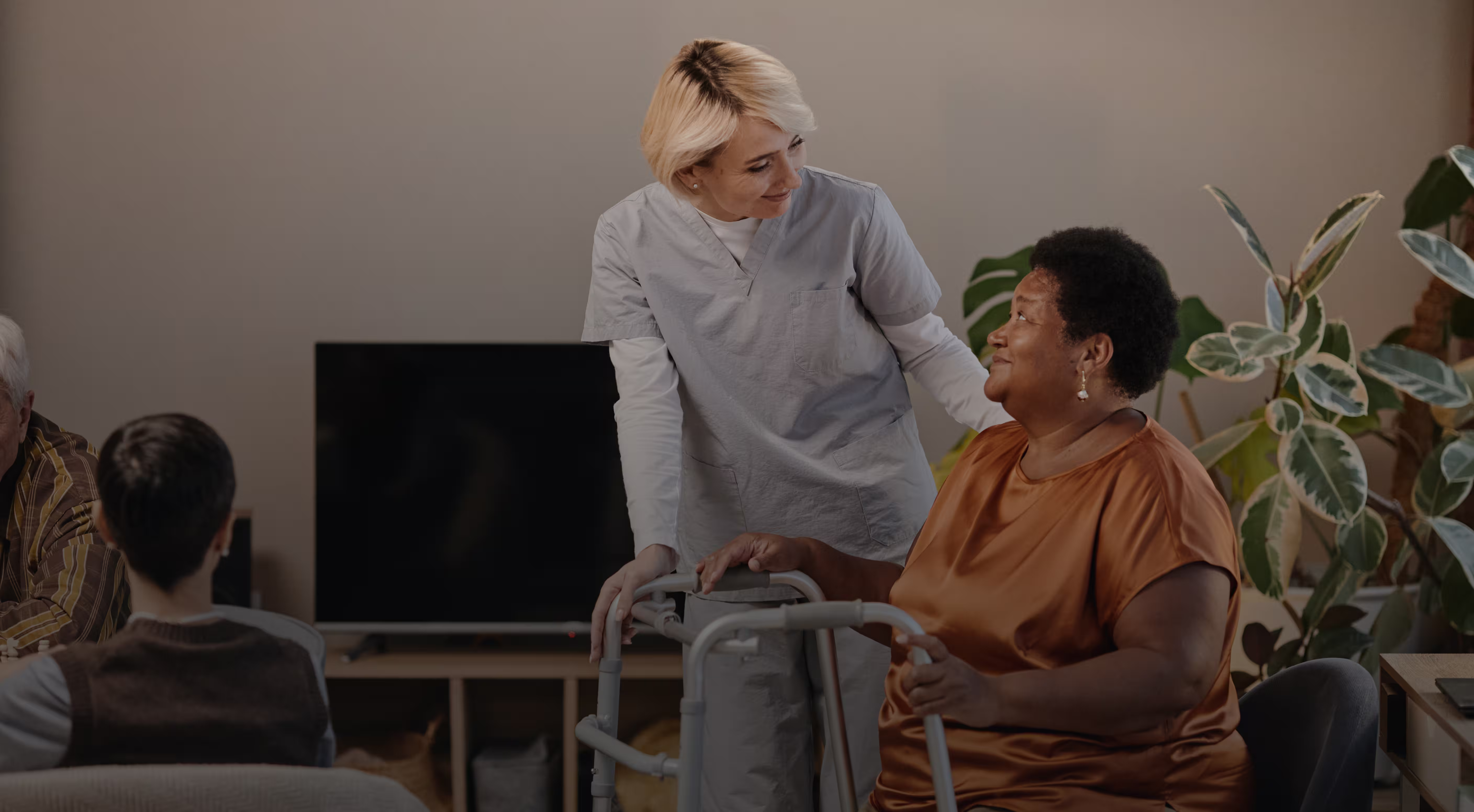 Professional care staff assisting senior resident